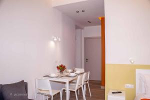 a dining room with a white table and chairs at Sirena Partenope e San Gennaro HOME - Rione Sanità - Centro Storico Napoli in Naples +6 photos