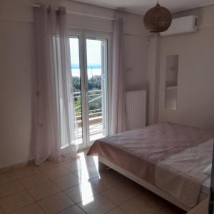 a bedroom with a bed and a large window at Villa Ioulia Malakonda, Eretria ,Greece in Eretria