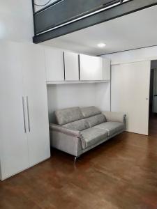 a couch in a living room with white cabinets at Maison 57 in Brindisi +6 photos