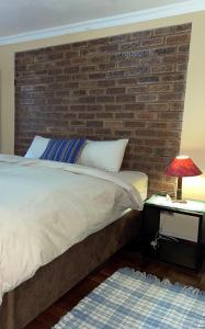 a bedroom with a brick wall and a bed at Timebridge Mansions in Johannesburg
