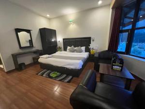 1 dormitorio con cama, sofá y mesa en Hotel Hadimba palace en Manāli