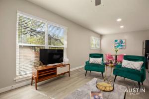 a living room with a flat screen tv and two green chairs at 7-Minute Walk to Deep Eddy Pool, Parking, and Grill in Austin