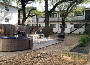 a backyard with a table and chairs and a fence at 7-Minute Walk to Deep Eddy Pool, Parking, and Grill in Austin