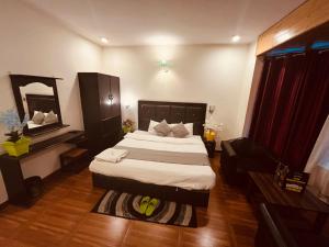1 dormitorio con 1 cama grande y espejo en Hotel Hadimba palace en Manāli