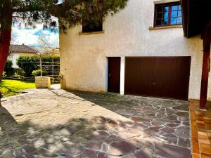 a building with a garage door and a driveway at Private Rooms & Bath in Tonneins