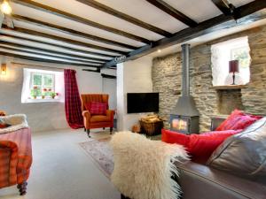 a living room with a couch and a fireplace at Holiday Home Llety Clyd by Interhome in Dinas Mawddwy