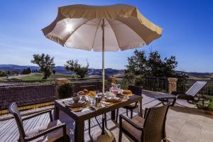 a table and chairs with an umbrella on a patio at Casa in campagna la Roverella in Francavilla dʼEte