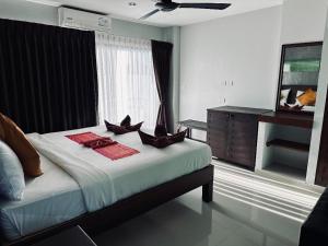 a bedroom with a bed with two pillows on it at Smile Home in Patong Beach