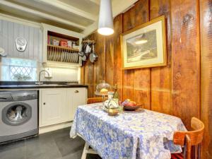 Llanfihangel-y-pennantにあるHoliday Home Dwyford by Interhomeのキッチン(テーブル、洗濯機付)