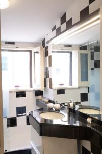 2 wastafels in een badkamer met 2 ramen bij San Colin casa vacanze in Conversano