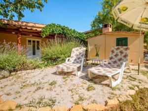 2 chaises et un parasol devant une maison dans l'établissement Holiday Home Taja by Interhome, à Split