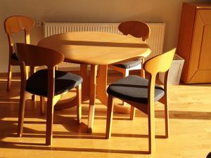 une table en bois et quatre chaises dans une chambre dans l'établissement Haus Marion, à Todtnau