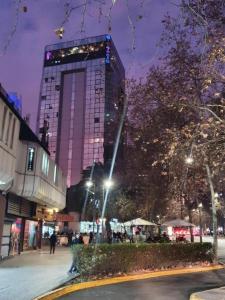 a tall building in a city at night at Departamento en Providencia cerca del Costanera Center in Santiago