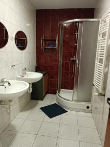 a bathroom with a shower and two sinks and a shower at Hostel Sunrise Liwska in Warsaw