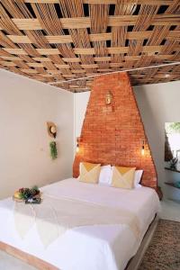 1 dormitorio con 1 cama grande y pared de ladrillo en ALOE Ecological Boutique Villa 3, en Ao Nam Mao