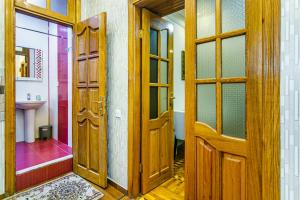 La salle de bains est pourvue d'une porte en bois et d'un lavabo. dans l'établissement Apartmet Kolorit, à Baku