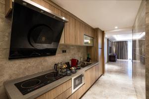 a kitchen with a sink and a large tv on the wall at Narcissus Obhur Resort & Spa in Jeddah