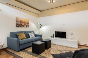 un soggiorno con divano blu e TV di Casa Ambrosini Apartments by Wonderful Italy a Bologna
