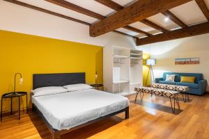 una camera con un letto e una parete gialla di Casa Ambrosini Apartments by Wonderful Italy a Bologna