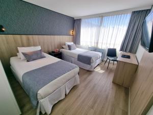 a hotel room with two beds and a television at Casa Spark Santiago in Santiago +21 photos