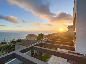 a sunset over the ocean from a house with stairs at Villa de la Ponte by Atlantic Holiday in Arco da Calheta