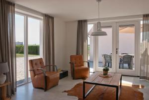 a living room with two chairs and a table at Vakantieverblijf de Trommel in Domburg