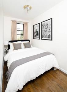 a white bedroom with a large white bed and a window at Cozy and new fully furnished 1BD/1BR in Park Slope in Brooklyn