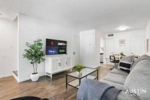 a living room with a couch and a tv at Walk to Everything - Fun Hyde Park Space King Bed in Austin