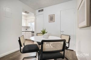 a dining room with a white table and chairs at Walk to Everything - Fun Hyde Park Space King Bed in Austin