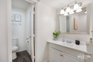 a white bathroom with a sink and a toilet at Walk to Everything - Fun Hyde Park Space King Bed in Austin +20 photos