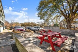 two red picnic tables in front of a parking lot at Walk to Everything - Fun Hyde Park Space King Bed in Austin