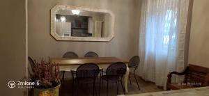 a dining room table with chairs and a mirror at HomeStory 2 via Idice 72 Pizzano BO in Casa Canovetta