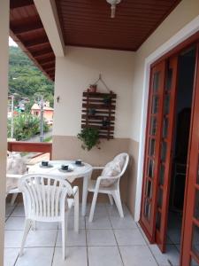 un patio con 2 sillas y una mesa en un porche en Apartamento praia da Armação, Florianópolis, en Florianópolis