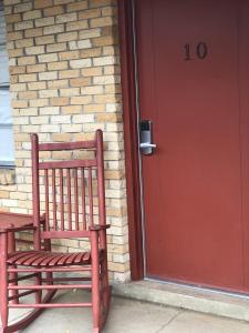 une porte rouge avec une chaise rouge devant une porte dans l'établissement JI11, Queen Guest Room at the Joplin Inn at the entrance to Mountain Harbor Resort Hotel Room, à Mount Ida