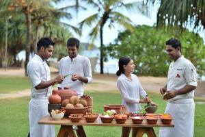 a group of people standing around a table with food at Weligama Bay Marriott Resort & Spa in Weligama
