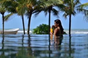 kobieta siedząca w wodzie w basenie w obiekcie Weligama Bay Marriott Resort & Spa w mieście Weligama