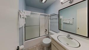 La salle de bains blanche est pourvue d'un lavabo et d'une douche. dans l'établissement Slopeside Four Bedroom Homes at 1849 Condos - Free Wifi & Parking!, à Mammoth Lakes