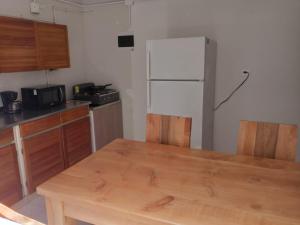 Il comprend une cuisine équipée d'une table en bois et d'un réfrigérateur. dans l'établissement Road Living Home, à Medellín