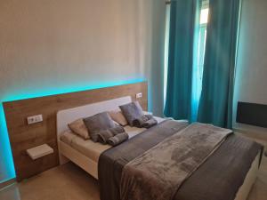Un dormitorio con una cama con luces azules. en Carthago Suites (Centro - Casco histórico), en Cartagena