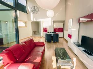 un soggiorno con divano rosso e TV di Apartment Rooftop Breeze by Interhome a Ostenda