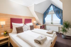 una camera con due letti e una finestra di Hotel Stadtidyll & Dependancen a Rotenburg an der Wümme