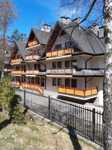 a large house with a fence in front of it at Apartament Tatrzański Jaszczurówka in Zakopane