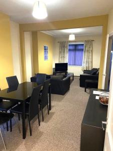 a living room with a black table and chairs at Royle House by SG Property Group in Northwich