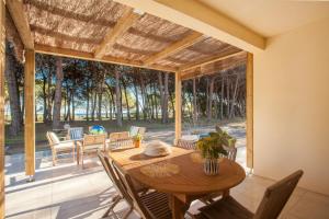 ein Esszimmer mit einem Tisch und einem großen Fenster in der Unterkunft MAISONS BORD DE MER- MARINE DE SORBO - Gîtes 3 épis in Pinarellu