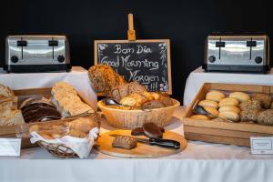 uma mesa com diferentes tipos de pães e doces em Vale d'Oliveiras Quinta Resort & Spa em Carvoeiro