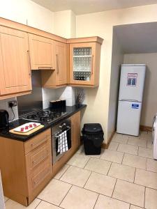 a kitchen with a stove and a refrigerator at Royle House by SG Property Group in Northwich