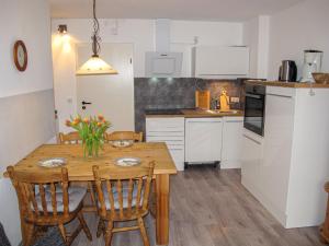 a kitchen with a wooden table with chairs and a dining room at Apartment Gollwitzer Park - Insel Poel-7 by Interhome in Gollwitz