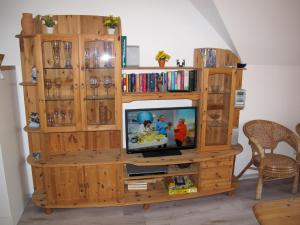 a wooden entertainment center with a television in it at Apartment Gollwitzer Park - Insel Poel-7 by Interhome in Gollwitz