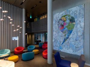 a room with colorful chairs and a large map of the world at b'mine hotel Düsseldorf in Düsseldorf