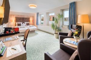 ein Wohnzimmer mit einem Bett und einem Tisch in der Unterkunft Hotel Stadtidyll & Dependancen in Rotenburg an der Wümme